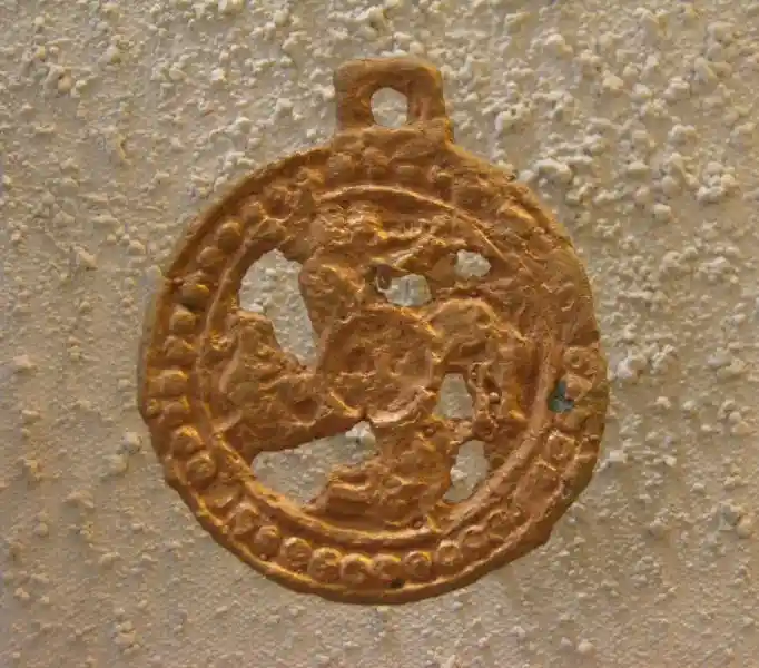 Pendant of solar disc with rounded swastika